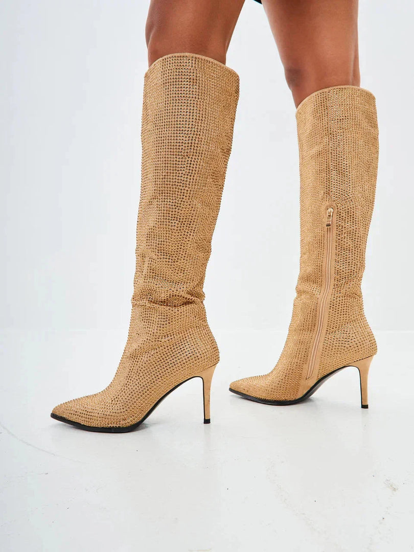 A pair of stunning gold stiletto knee-high boots with intricate jewel embellishments, perfect for making a glamorous statement.