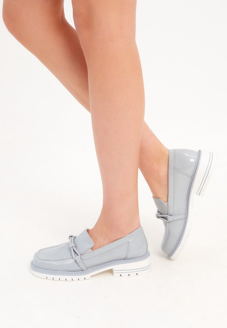 A stylish pair of women's blue block heels loafers, perfect for a fashion-forward look.