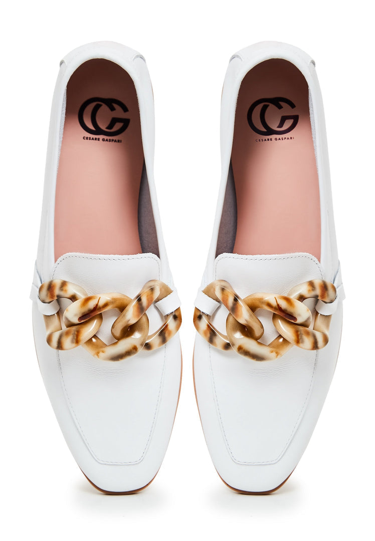 A pair of stylish white leather flat loafers with a classic design and a flat sole, perfect for any occasion.