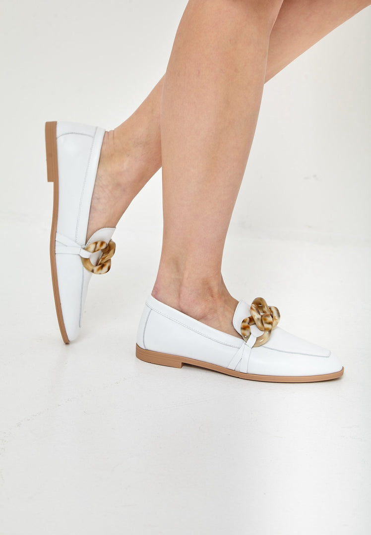A pair of classic white leather loafers with a flat sole, ideal for any stylish outfit.