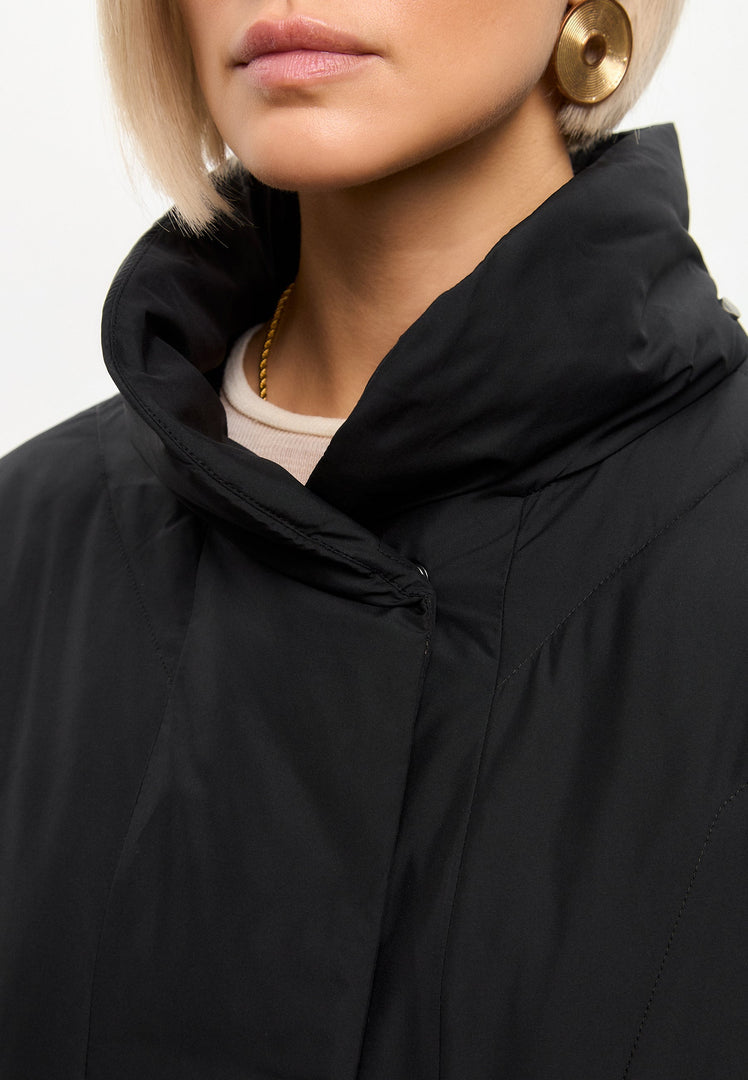 A stylish black quilted coat, perfect for winter outerwear, that is fashionable and flattering for women, with a long silhouette.