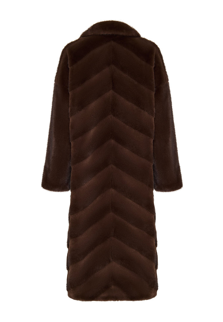 A stylish woman wearing an oversized brown faux fur coat, the perfect trendy statement piece for winter fashion in women's outerwear.