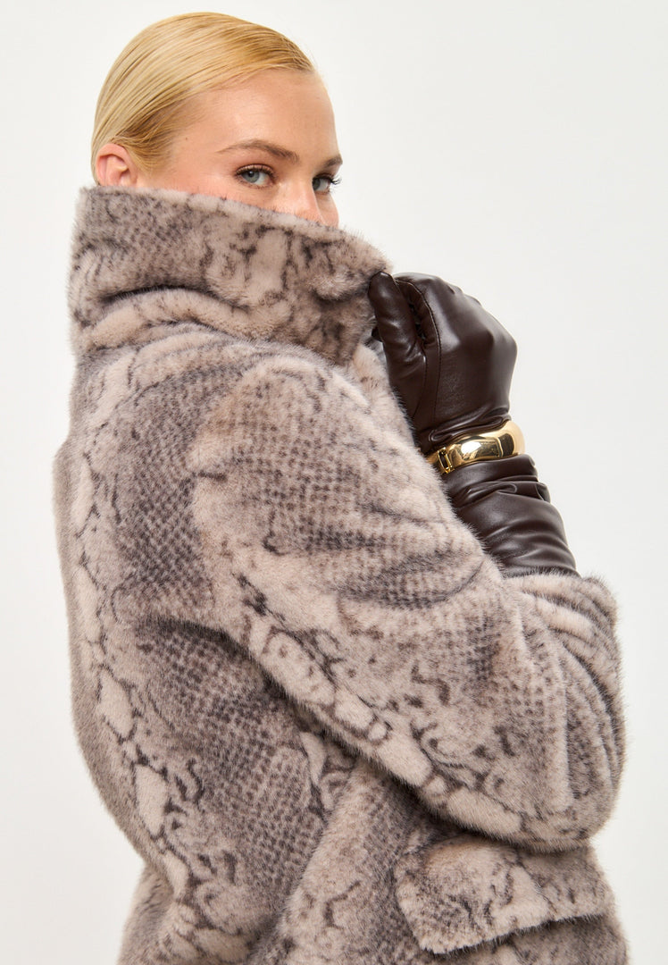 A trendy winter fashion statement featuring a stylish beige faux fur Niuvis coat with snake print design.